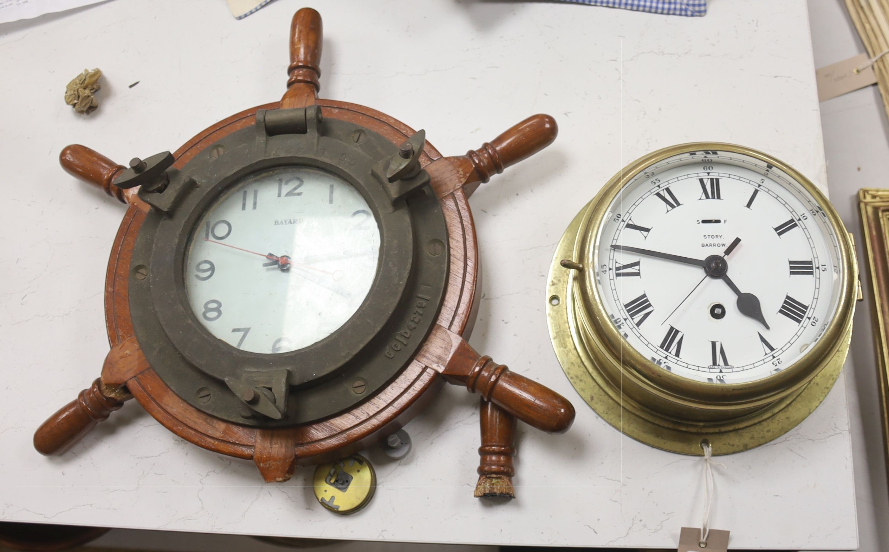 A brass bulkhead timepiece, enamelled dial signed Story, Barrow, dial 17cm, and a ship's wheel wall timepiece by Bayard